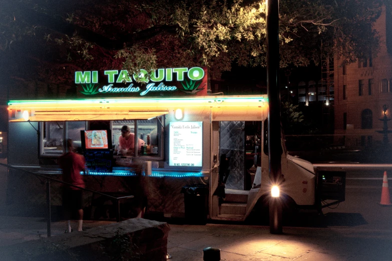 a food cart in the dark with neon lights at night