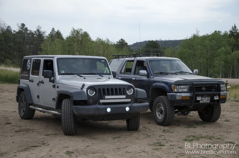 two grey jeeps parked side by side