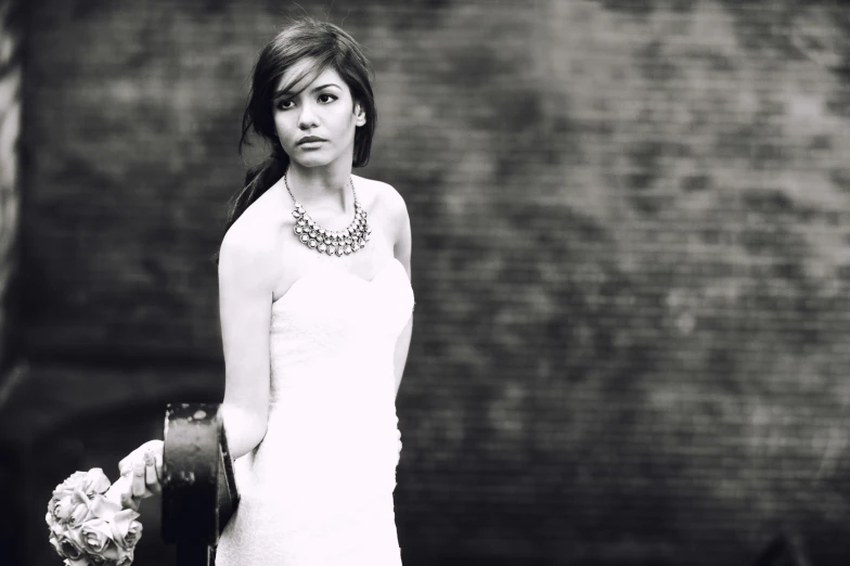 a beautiful young woman in a short dress standing next to a wall