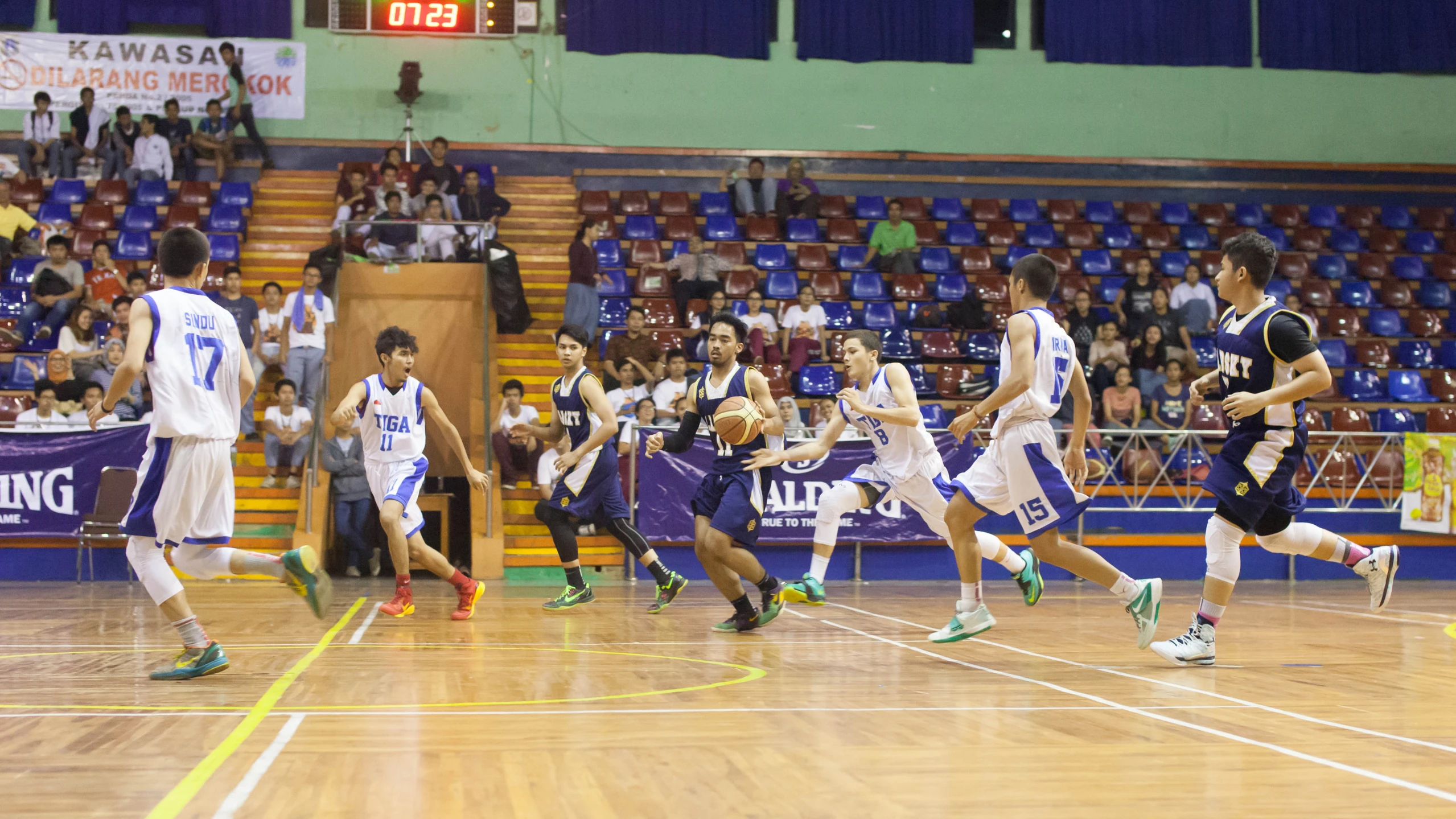 many people in uniforms and one man is throwing a ball