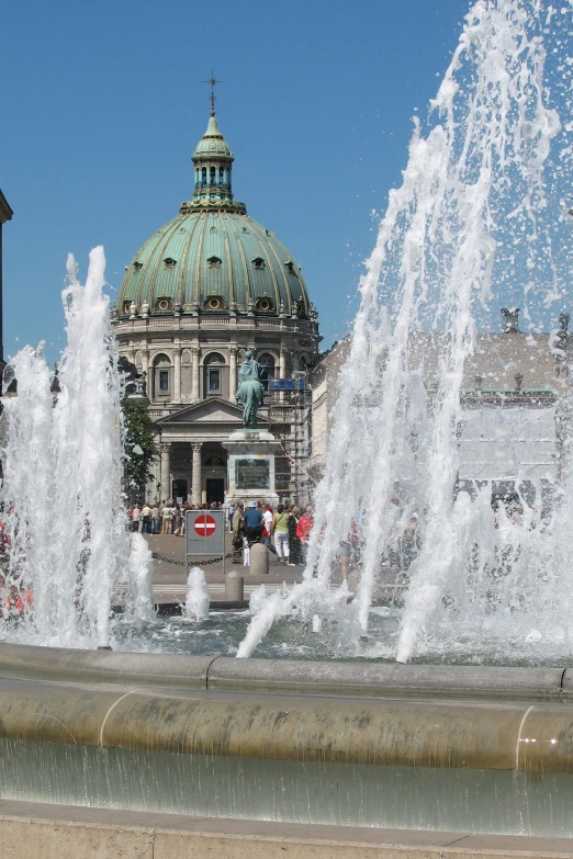 a large building next to a fountain on a city street