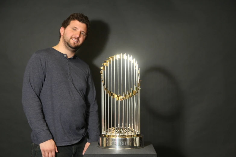 the man is posing for a po next to a trophy