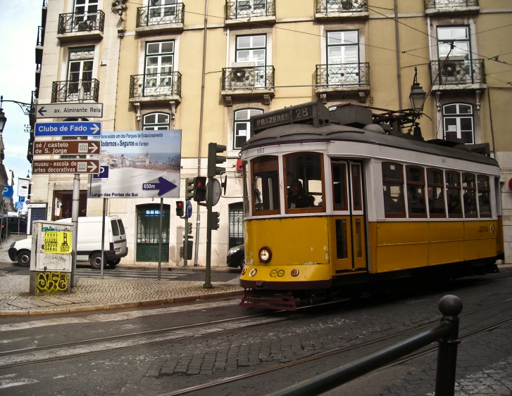 a trolley car on a city street near a building