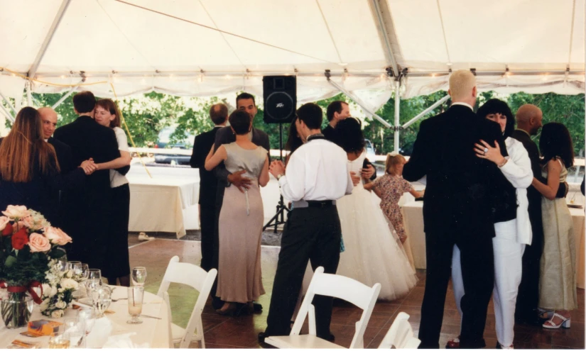 there are many people standing in a tent together