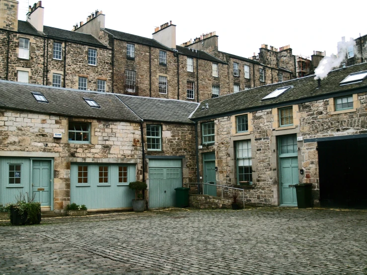 two blue doors and two green shutters at a courtyard