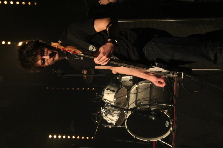 a man standing next to a drum set