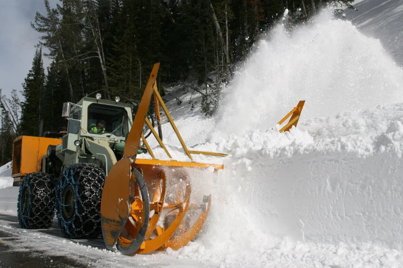 the plow is shoveling the snow off from the side of the road