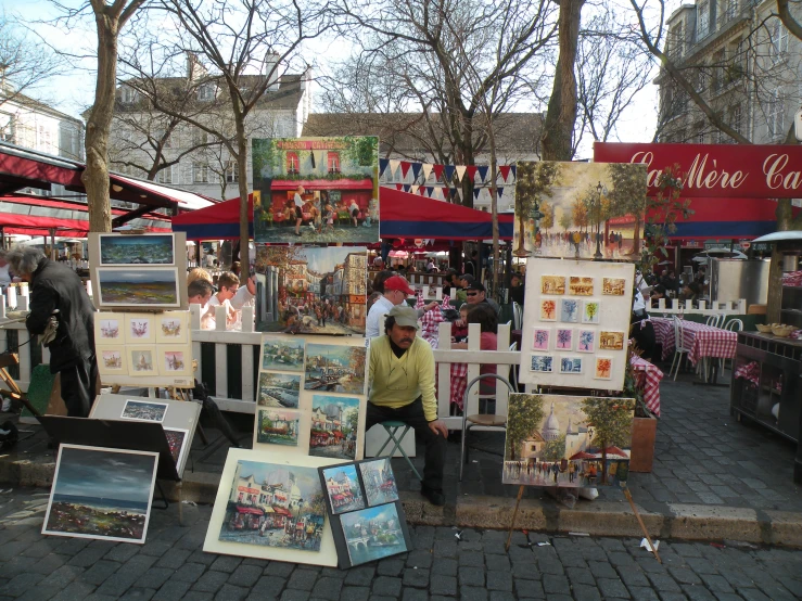 people standing around a display with pictures and paintings