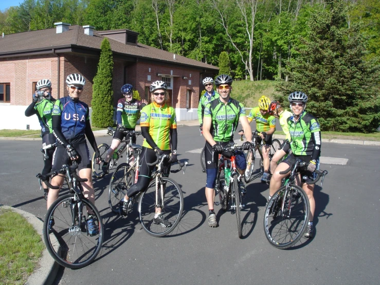 seven cyclists posing in front of a lodge