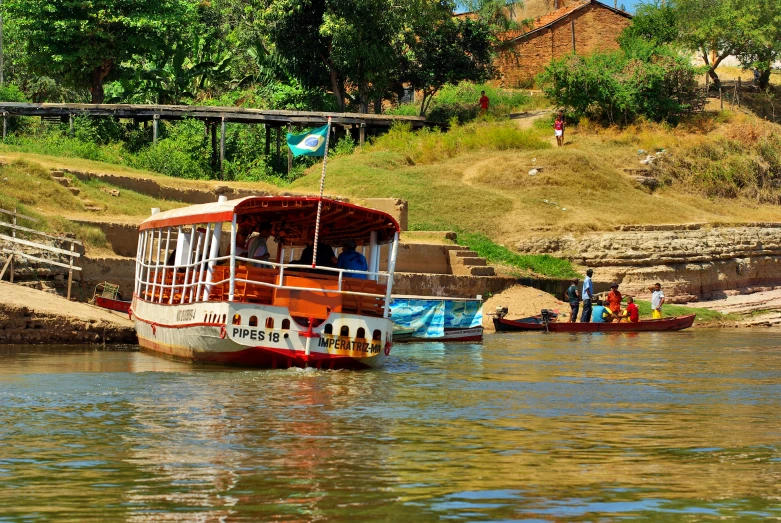 three boats in the river with people on them