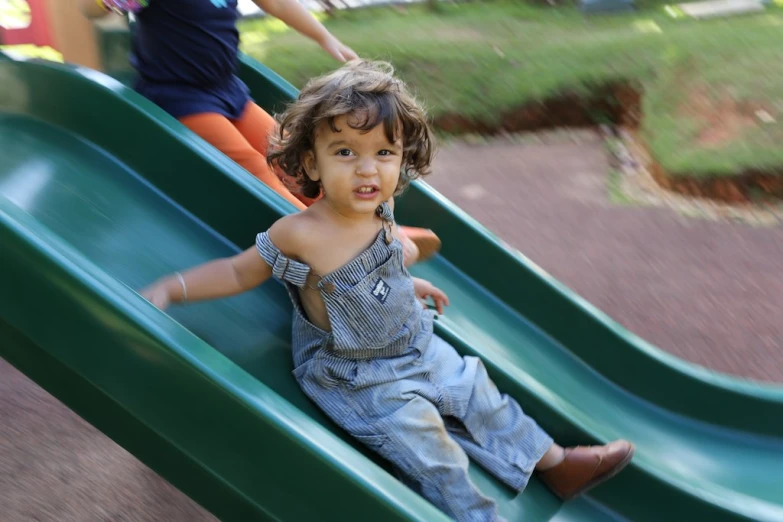 a young child sitting on top of a slide