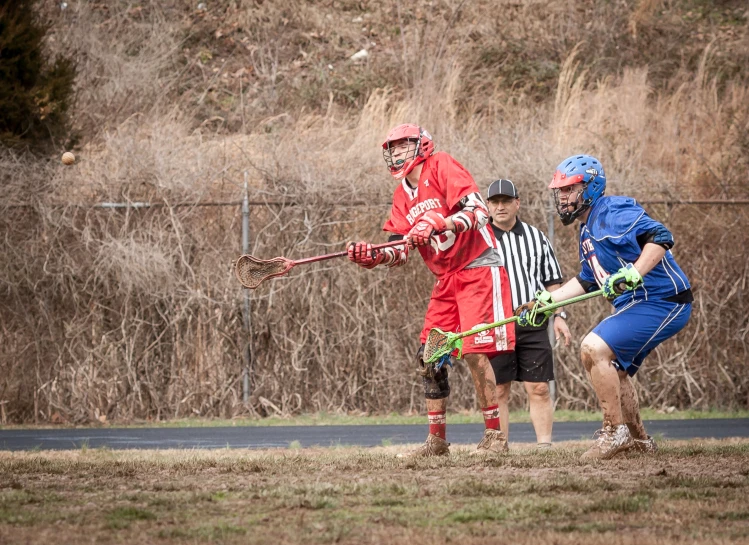 men playing in a lacrosse game on a grass field