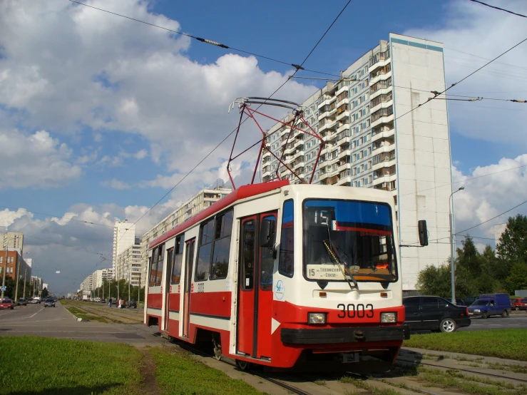 an old tram traveling past a tall building in the city