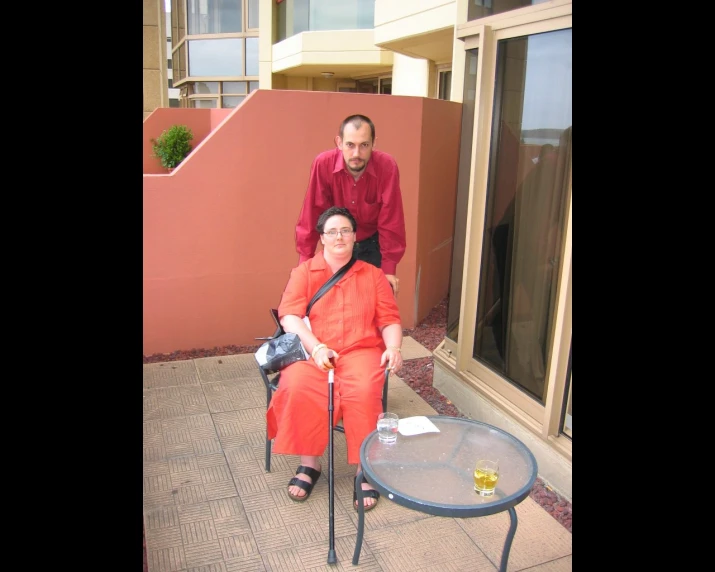 a man and woman sit on chairs outdoors in the daytime