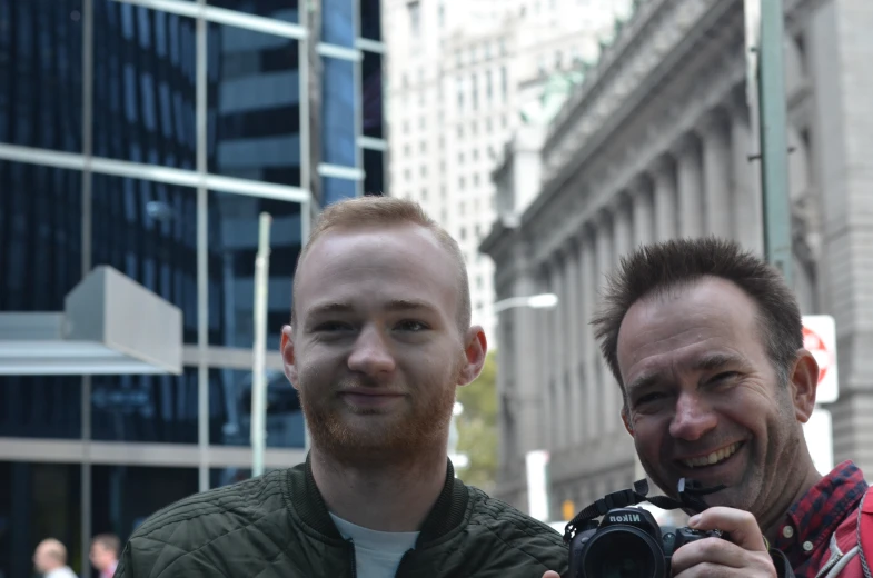 two men taking a picture of themselves on the street