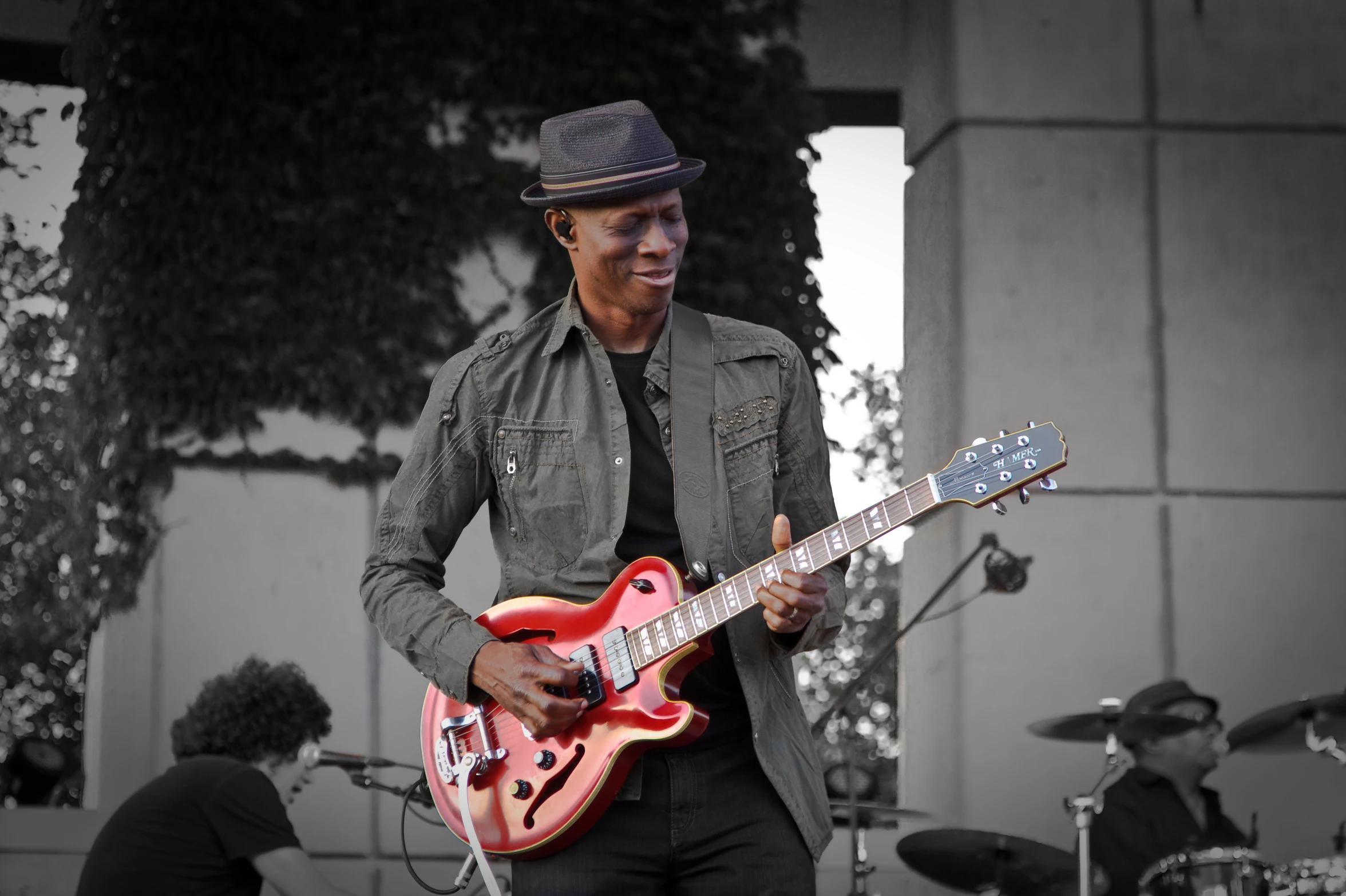 a man holding a red guitar on stage