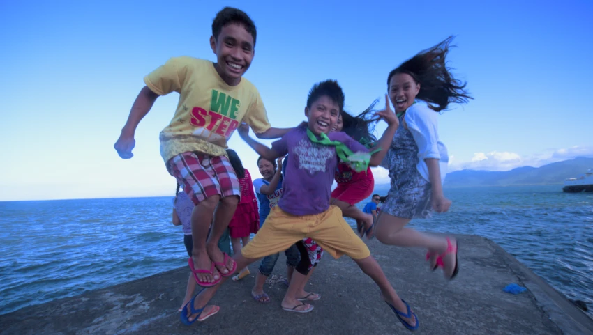 several s pose for a picture while standing on a rock next to the water