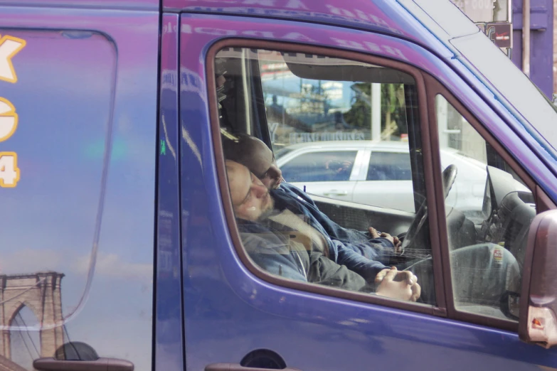 a man driving in the back seat of a blue truck