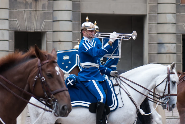 a man in a blue outfit playing on a trumpet
