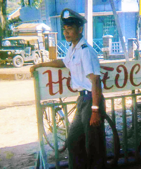 a man in uniform and hat standing next to a sign