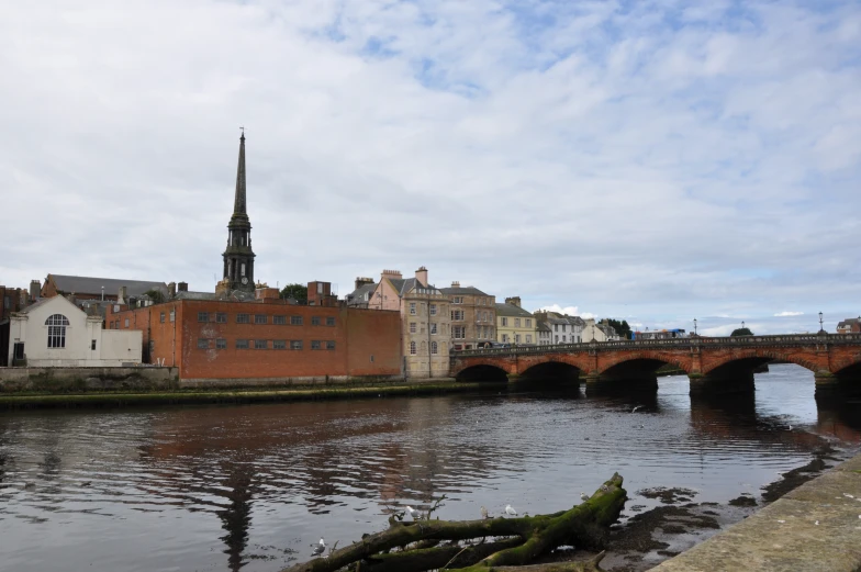 the bridge is across the river from houses on the other side