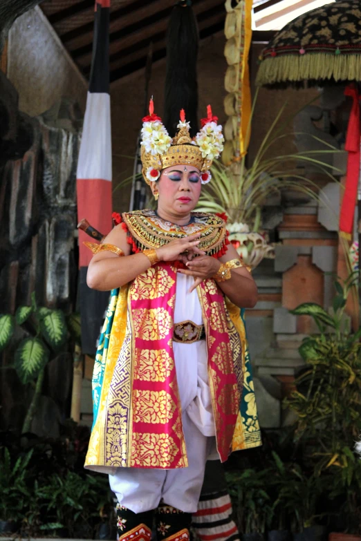 a person dressed as a queen wearing costume on stage