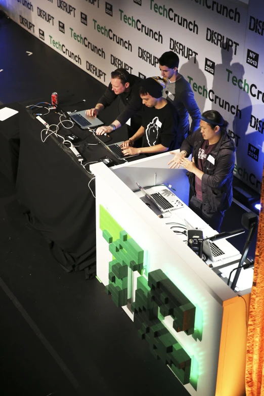 a table with four people working on some electronics