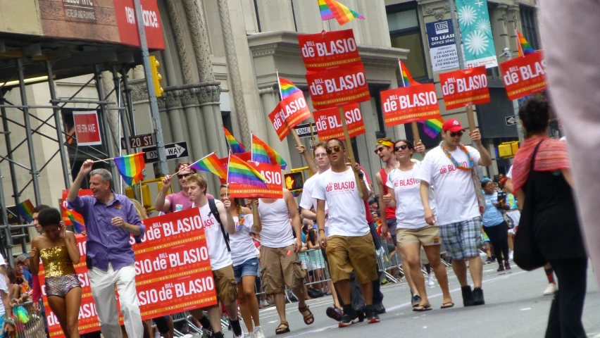 a group of people walking down the street holding colorful signs