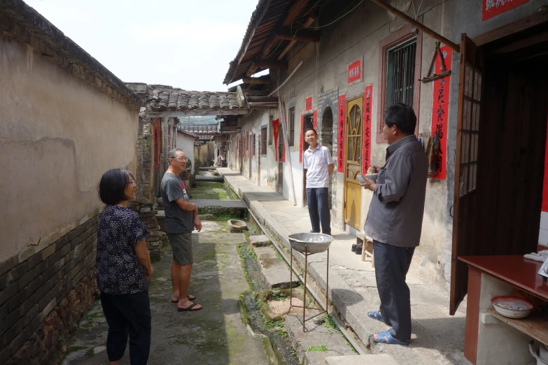 three women are standing outside and another woman is holding soing in her hand