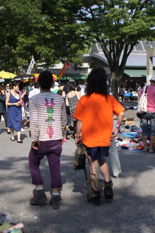 two people ride skateboards near people with umbrellas