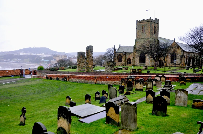 cemetery with grassy area and old cathedral next to water