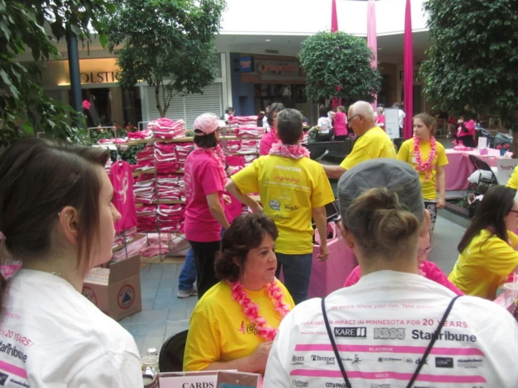 group of people dressed in pink and yellow and some of the rest of the group are wearing shirts