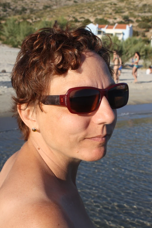 a woman in sunglasses is staring away from the water