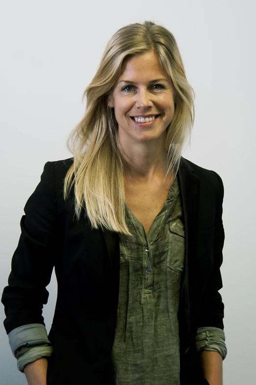 a woman in jacket smiling for the camera