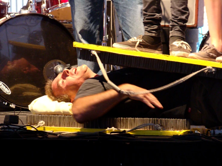 a man laying on his back in front of a drum kit