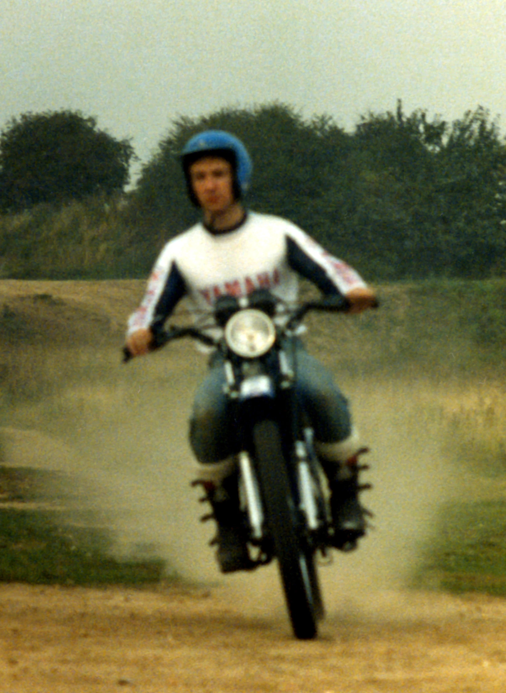 the man is riding a dirt bike on a dirt road