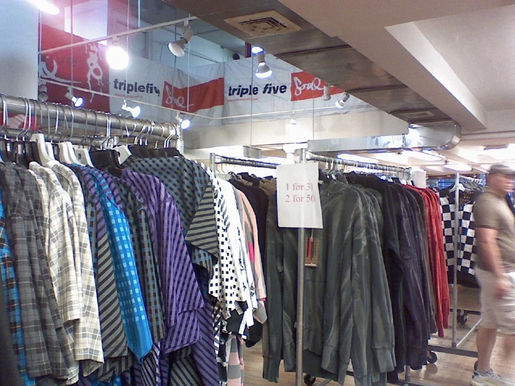 a store with a rack of shirts for sale