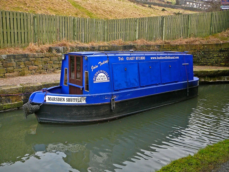 a blue boat parked at the end of a canal