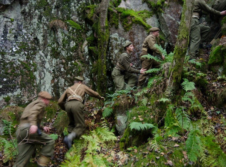 a group of soldiers climbing up some rocks