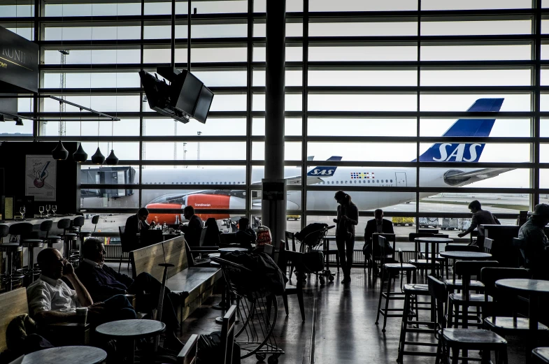 a crowded airport terminal with airplanes on the runway