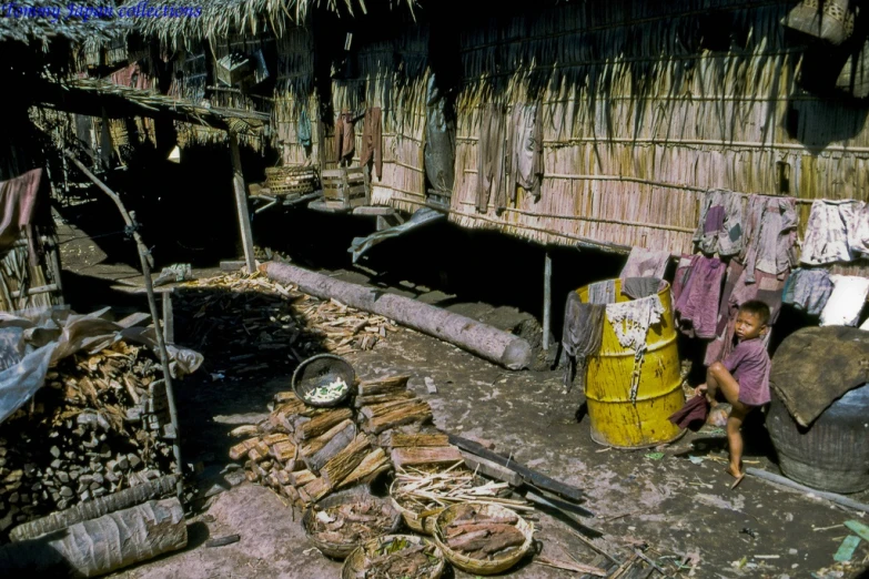 an old man sitting outside a small shack