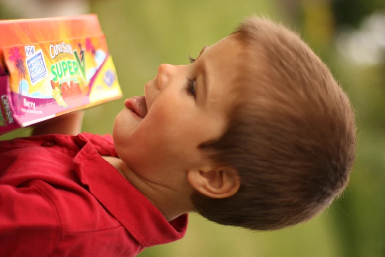 little boy opening a package of fruit flavored treats