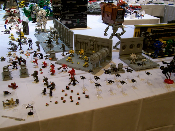 a table filled with many toy figurines, including a war machine