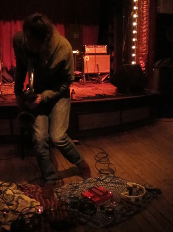 a person sitting on the floor by himself on a stage