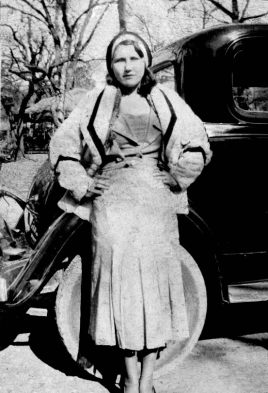 a black and white po of a woman in front of a car