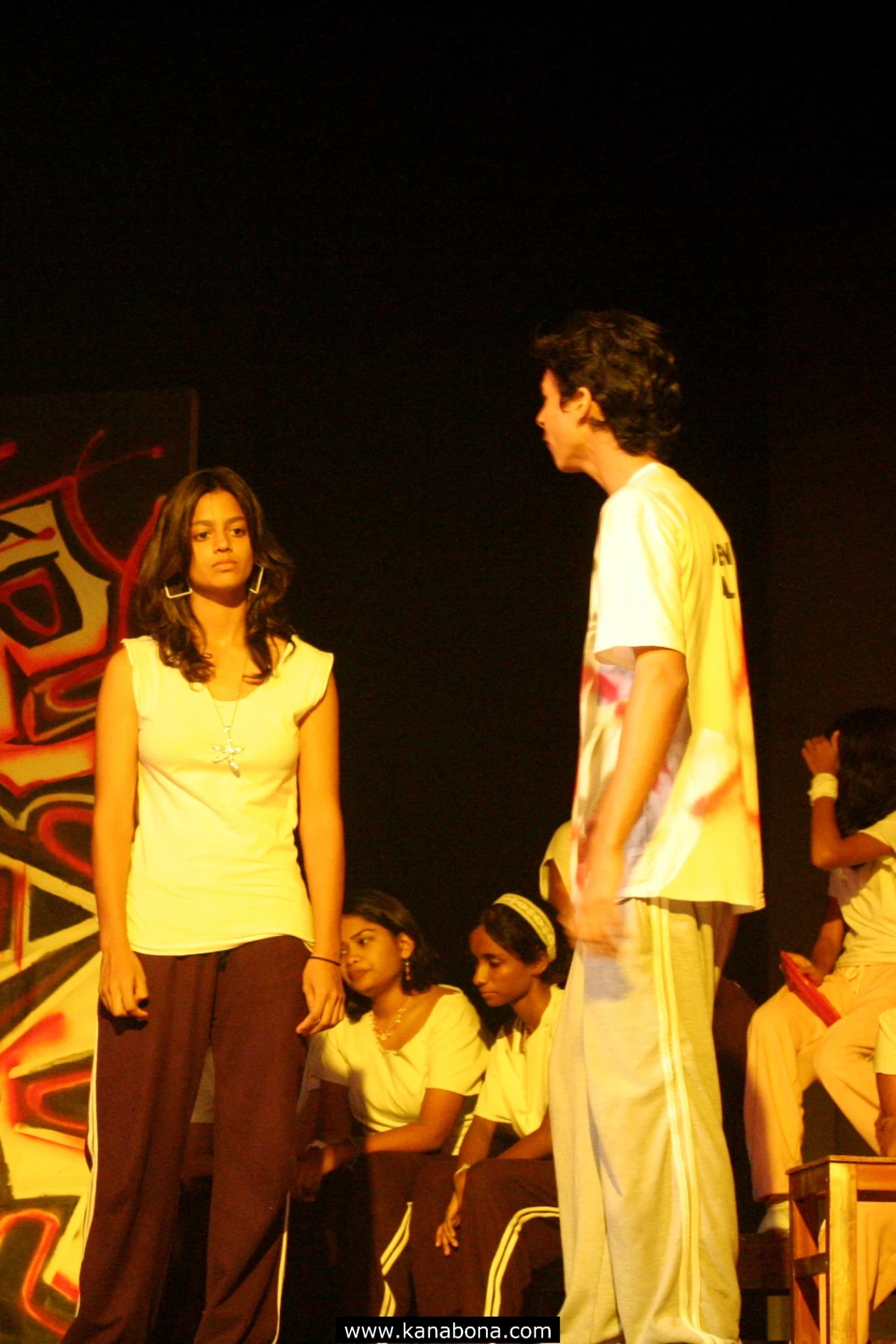 a man and woman on a stage with other performers behind them