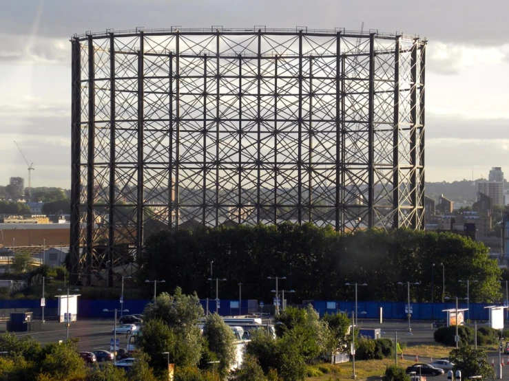 a tall tower with metal spiral design and many cars around it