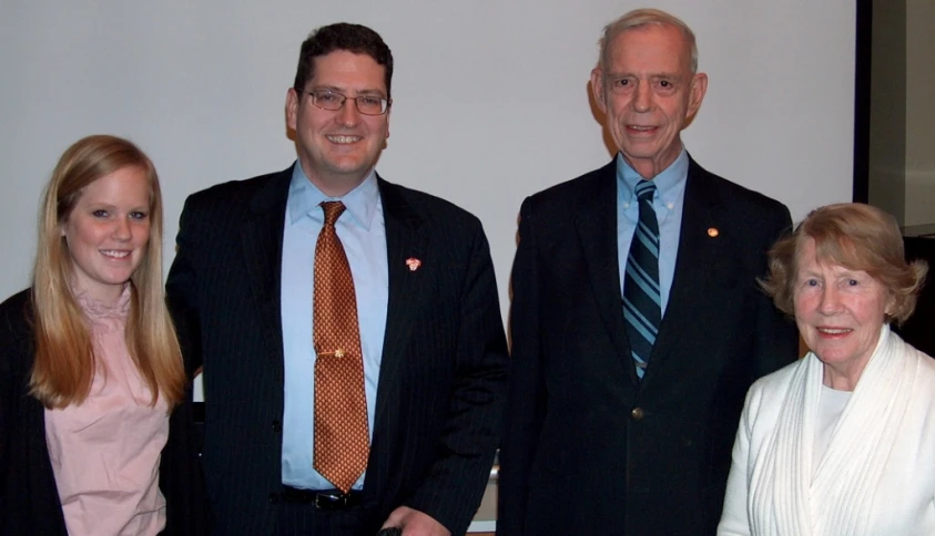 three people standing next to each other posing for the camera