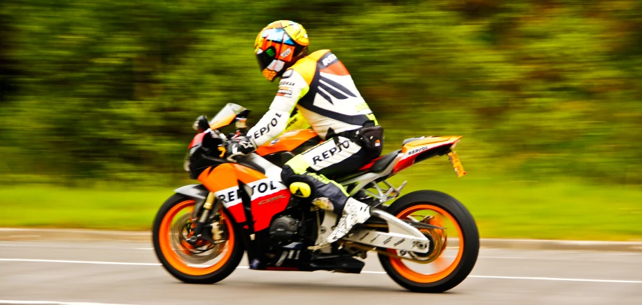 a person riding on the back of an orange motorcycle