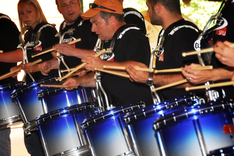 a group of drummers in black shirts with their drums